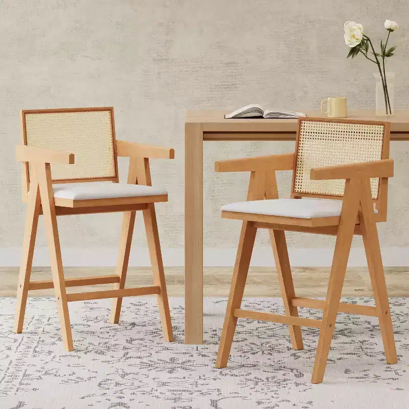 Sgabelli da bar Okak (set da 2) in legno massello ad altezza bancone per sale da pranzo, poltrone con schienale in rattan per isole cucina, finitura naturale