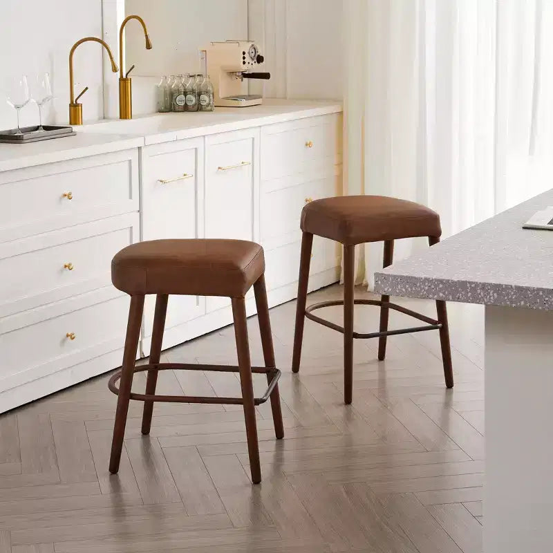 Set di 2 moderni sgabelli da bar Okak imbottiti e confortevoli con poggiapiedi e robusta struttura in metallo, seduta senza schienale altezza bancone