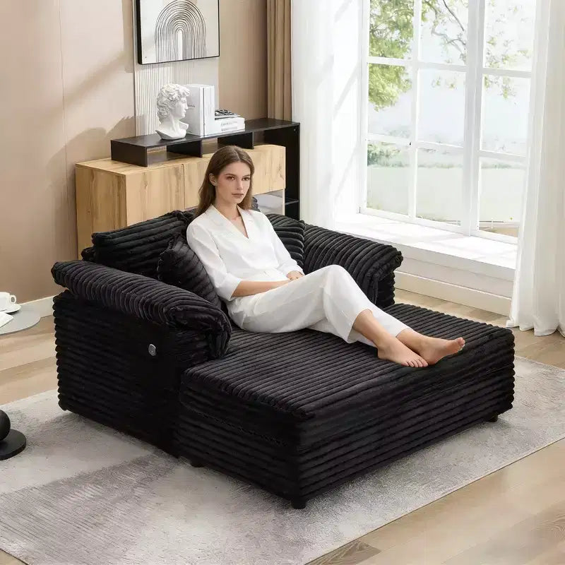 Poltrona chaise longue oversize da interno, comodo divano lounge in velluto a coste con ampi braccioli imbottiti e cuscini decorativi, accogliente divano letto per soggiorno